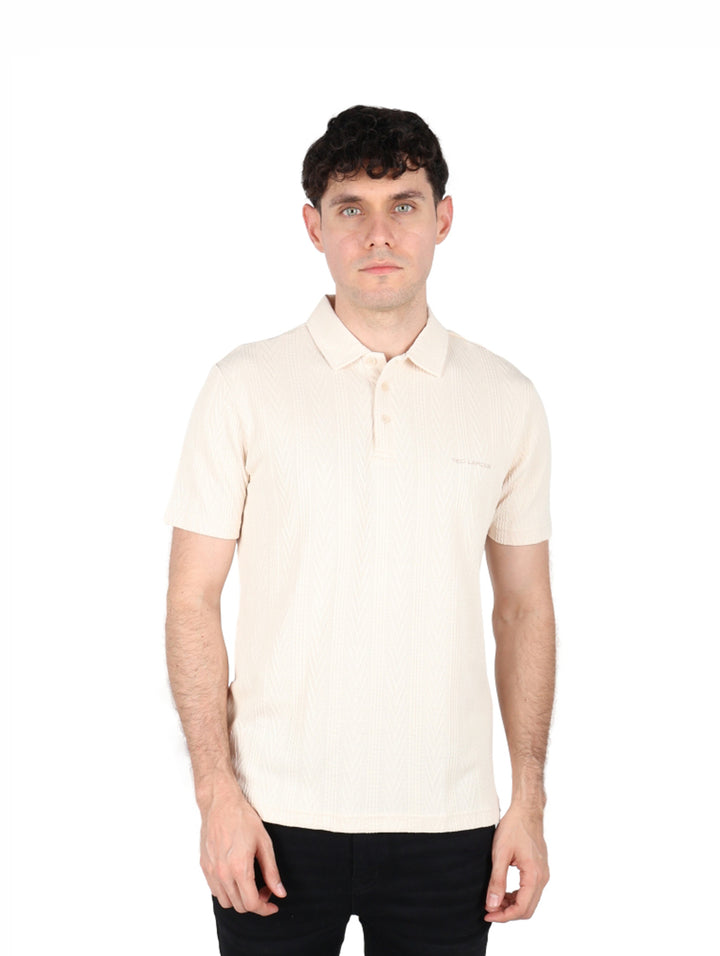Hombre vistiendo playera polo color beige de manga corta marca Ted Lapidus.