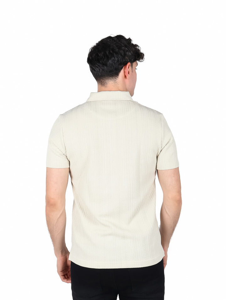 Hombre vistiendo playera polo color beige de manga corta marca Ted Lapidus.