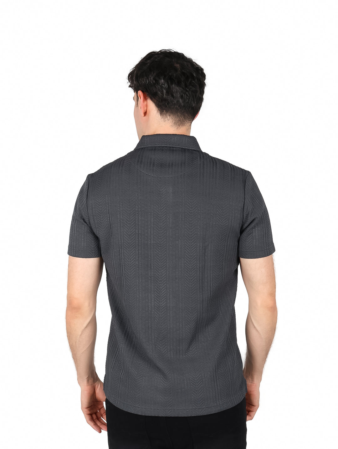 Hombre vistiendo playera polo color gris oscuro con textura vertical, cuello y manga corta.
