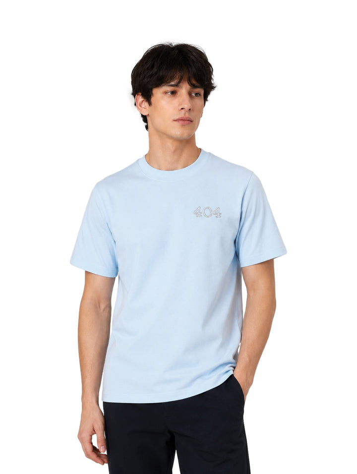 Hombre vistiendo una playera de manga corta color azul claro con el número 404 en el pecho.