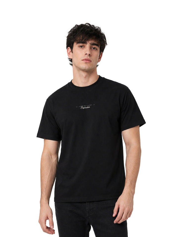 Hombre vistiendo playera color negro de manga corta marca Republic con texto pequeño en el pecho.