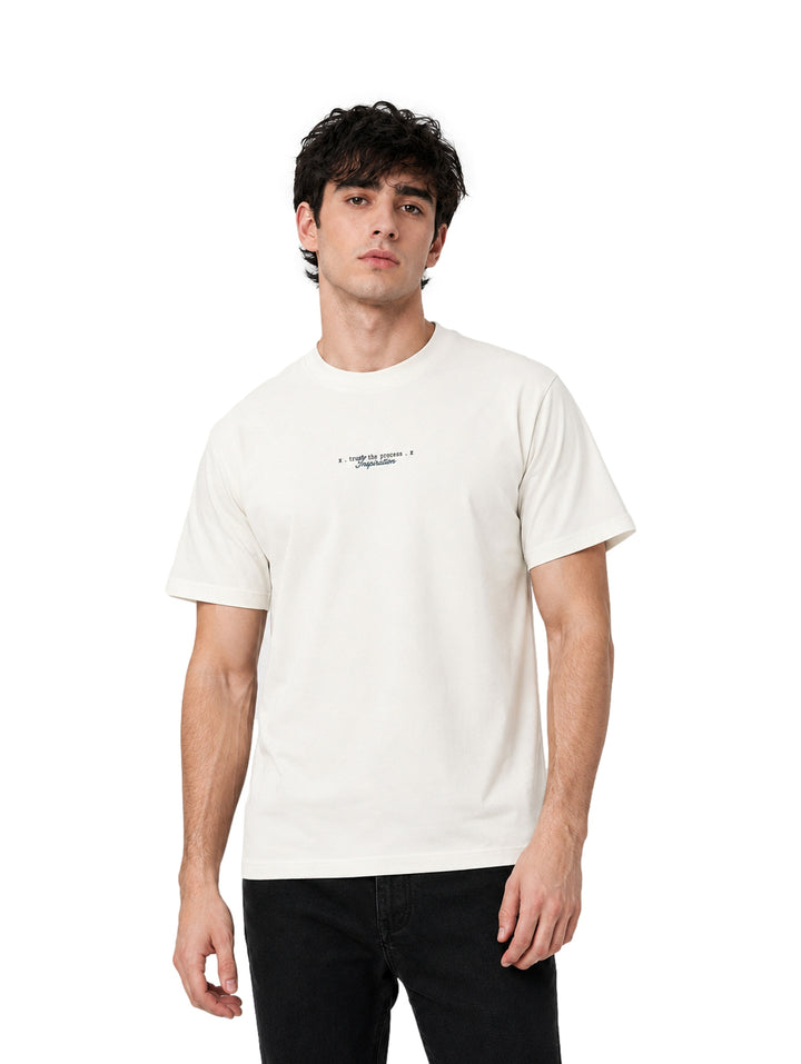 Hombre vistiendo una playera blanca de manga corta y cuello redondo.