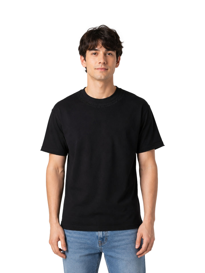 Hombre vistiendo una playera negra de manga corta y cuello redondo de la marca Republic.