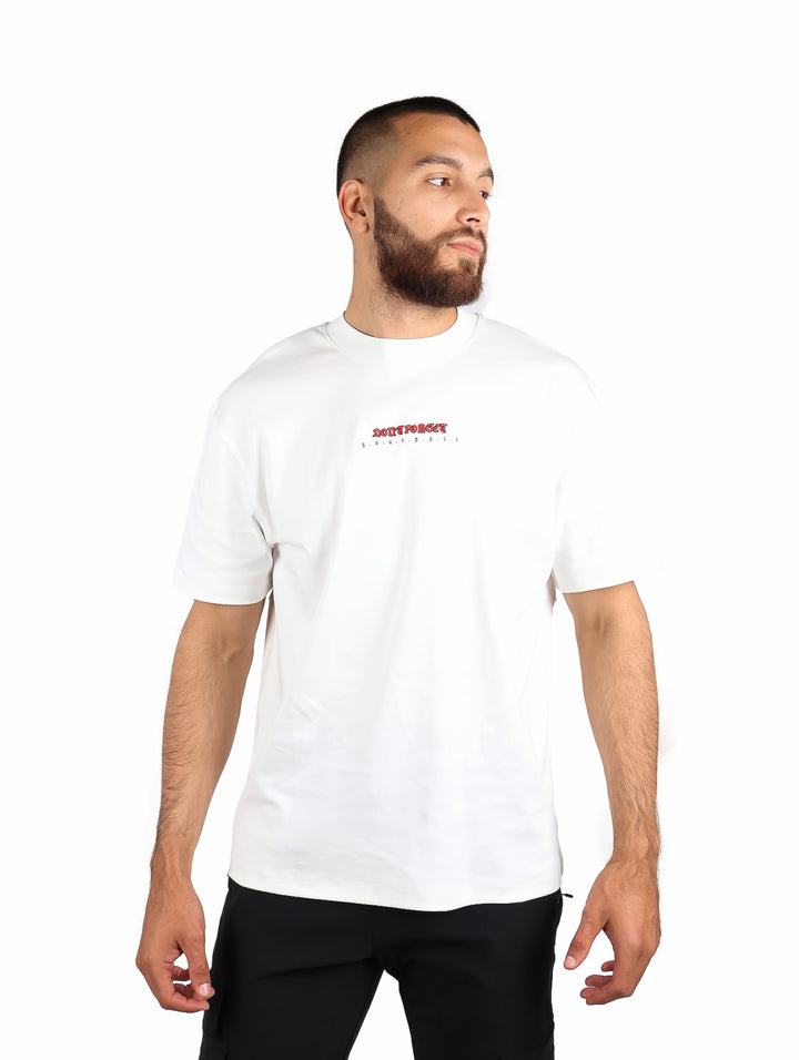 Hombre vistiendo una playera blanca de manga corta marca Republic con un pequeño logo rojo en el pecho.