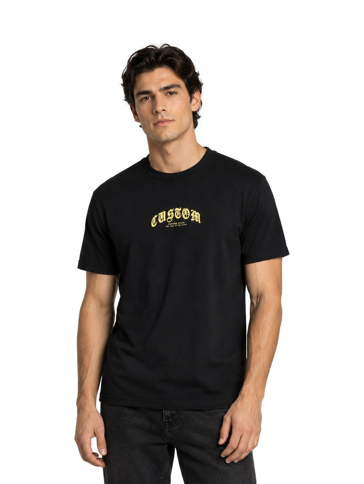 Hombre vistiendo playera negra de manga corta con estampado dorado en el pecho.