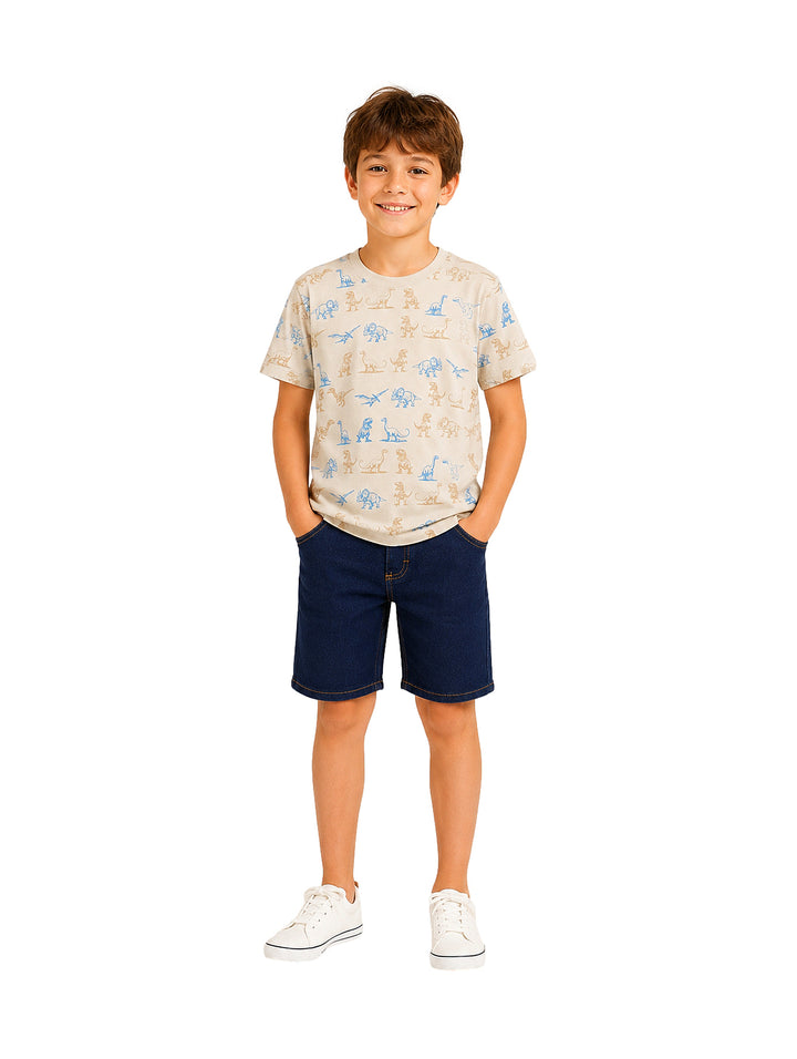 Niño vistiendo un conjunto de camiseta beige con estampados de dinosaurios y shorts azul marino.