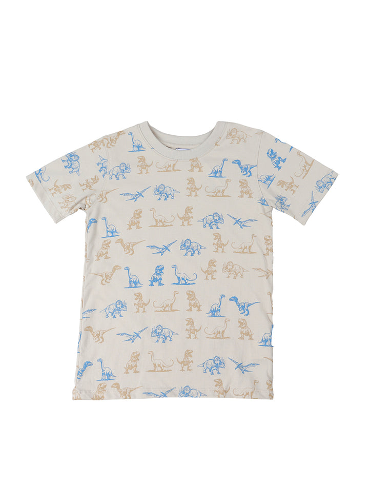 Niño vistiendo un conjunto de camiseta beige con estampados de dinosaurios y shorts azul marino.