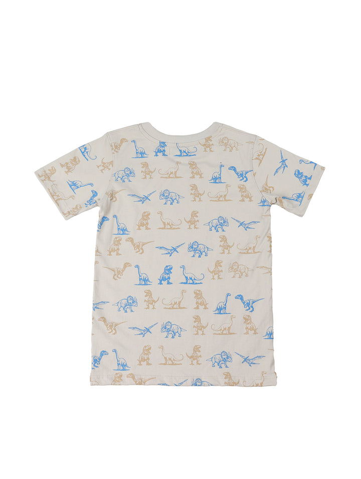 Niño vistiendo un conjunto de camiseta beige con estampados de dinosaurios y shorts azul marino.