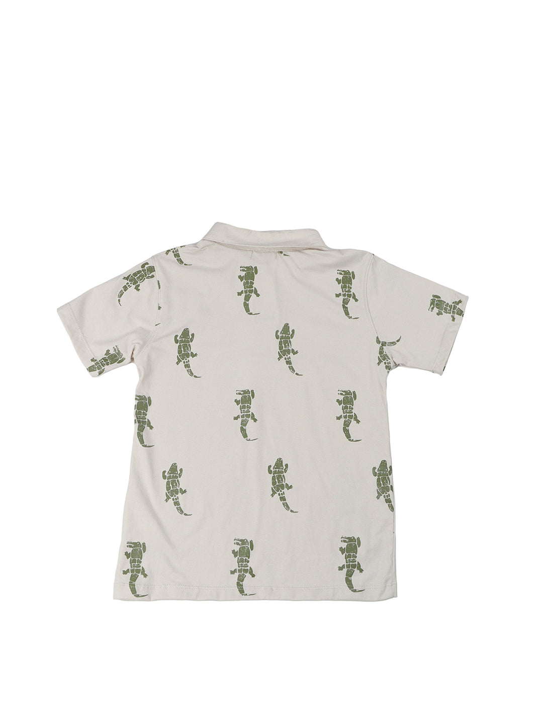 Niño vistiendo un conjunto de polo beige con estampado de lagartos y short azul marino.
