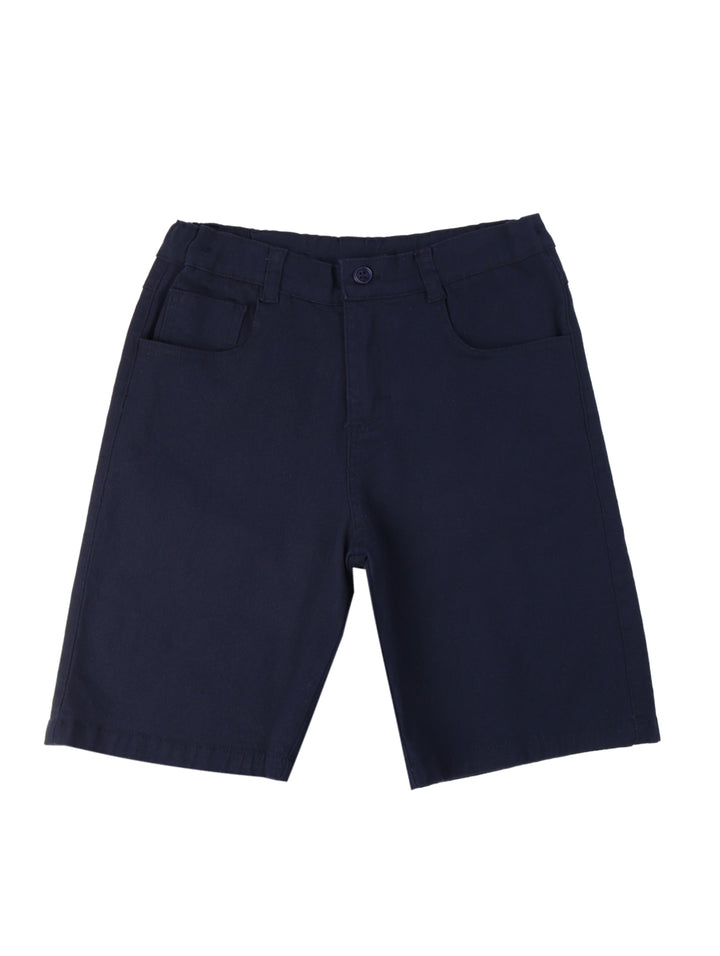 Niño vistiendo un conjunto de polo beige con estampado de lagartos y short azul marino.