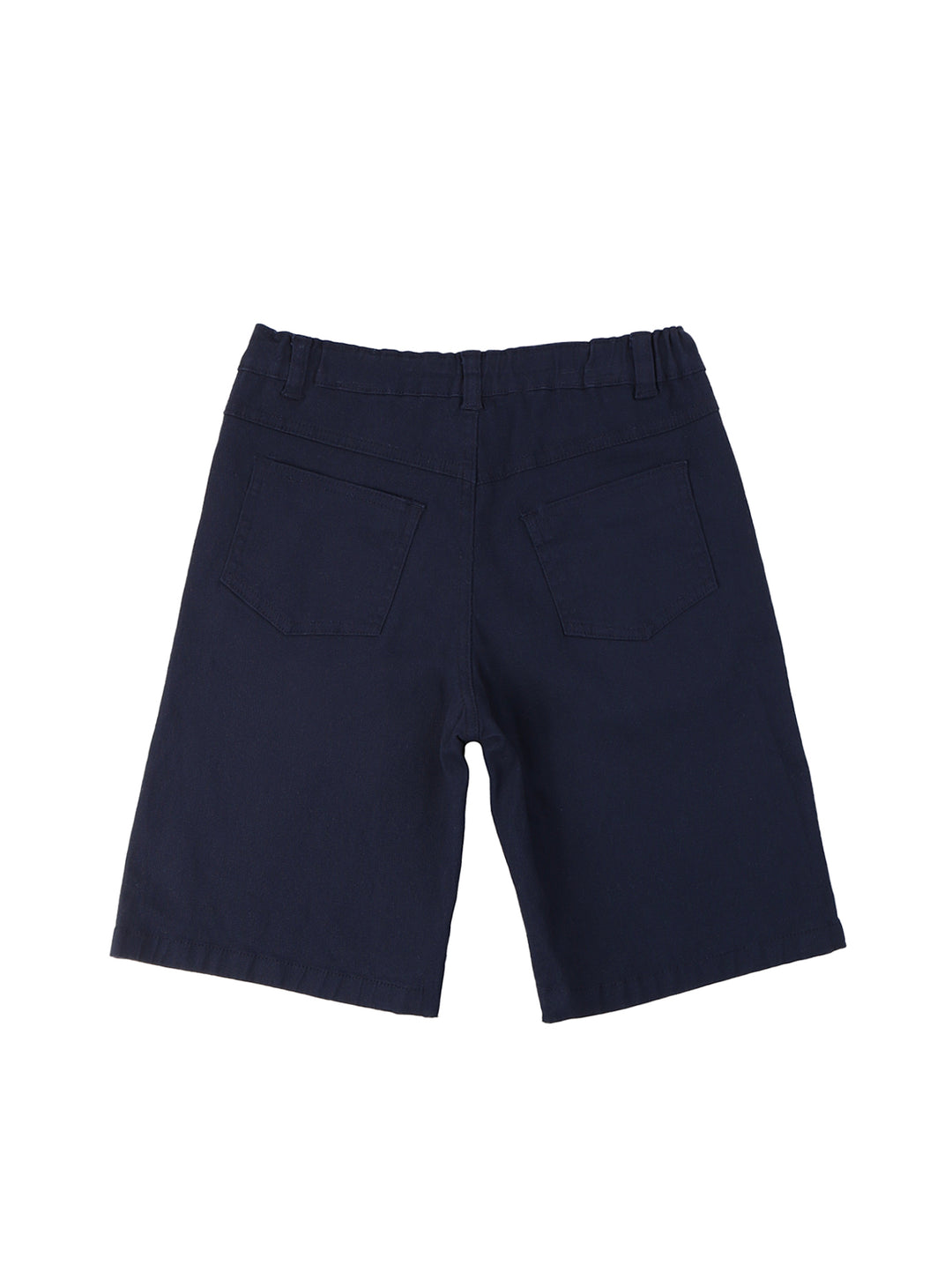 Niño vistiendo un conjunto de polo beige con estampado de lagartos y short azul marino.