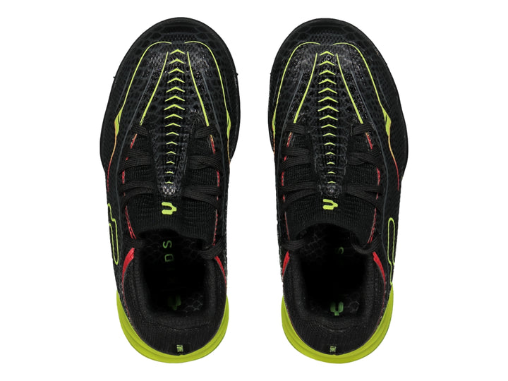 Zapato de fútbol Charly modelo Turf en color negro con detalles en amarillo neón y rojo.