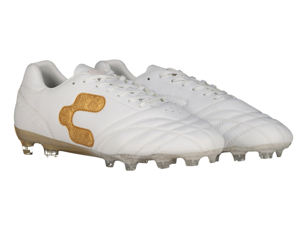 Zapato de fútbol Charly color blanco con detalles en dorado y suela de tacos transparente.