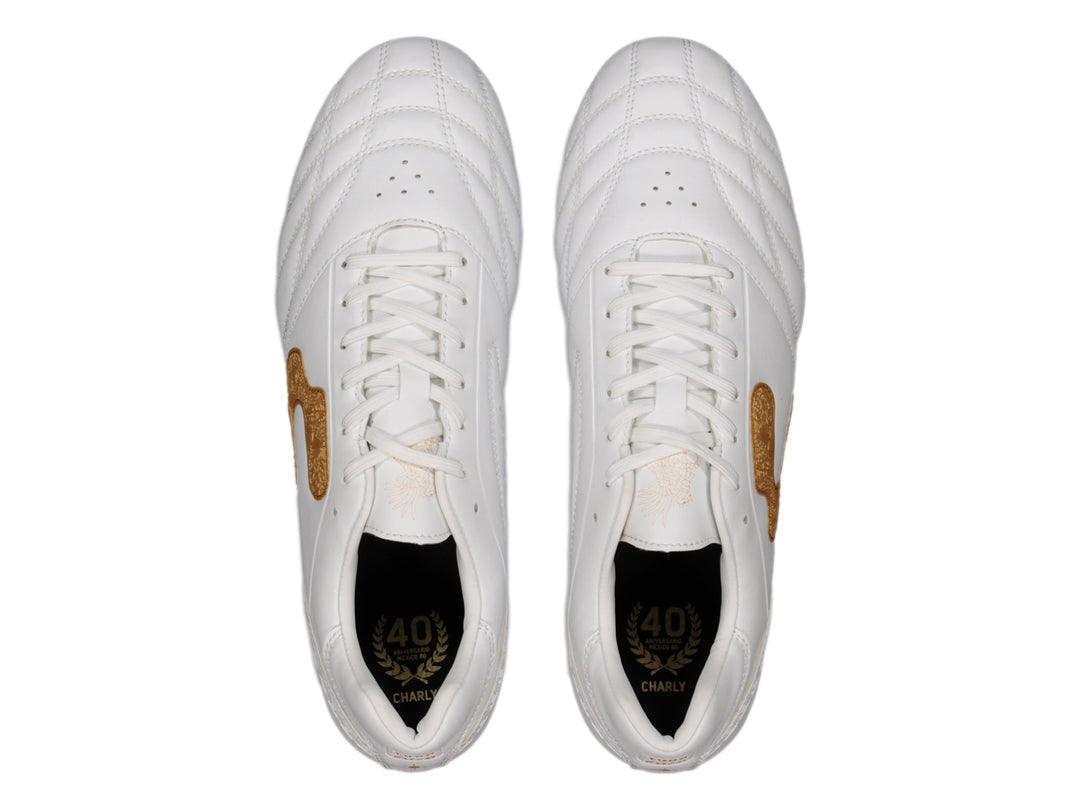 Zapato de fútbol Charly color blanco con detalles en dorado y suela de tacos transparente.