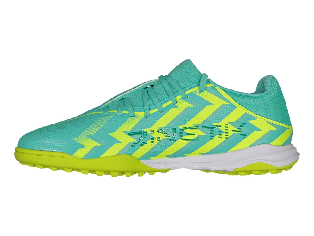 Zapato de fútbol turf Charly color turquesa con patrones zig-zag amarillos y suela amarilla.