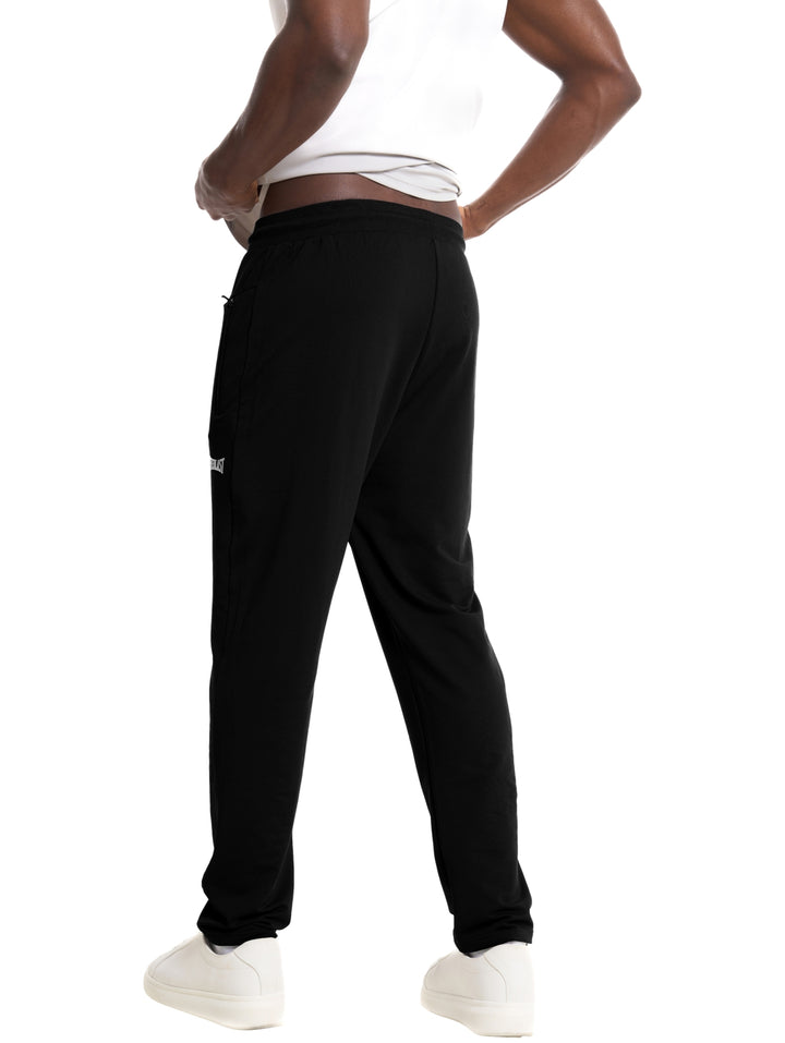 Hombre vistiendo pantalón deportivo negro de la marca Everlast con cordones en la cintura y bolsillo lateral.