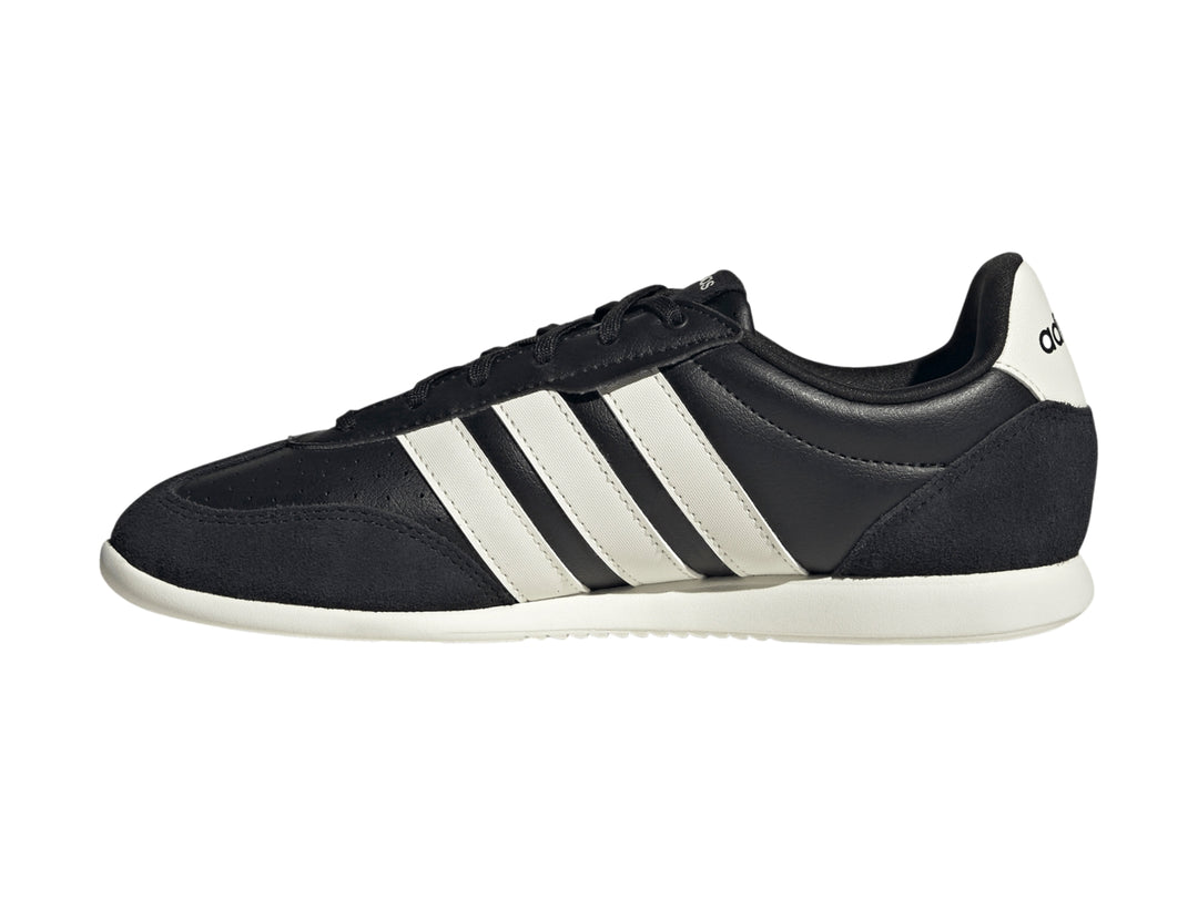 Tenis deportivos Adidas color negro con tres franjas blancas laterales y suela blanca.