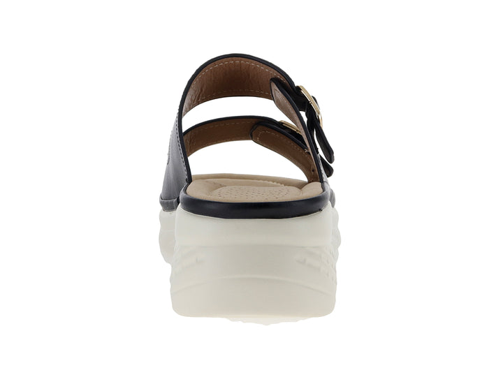 Sandalia negra de plataforma con dos correas ajustables mediante hebillas doradas y suela blanca gruesa.
