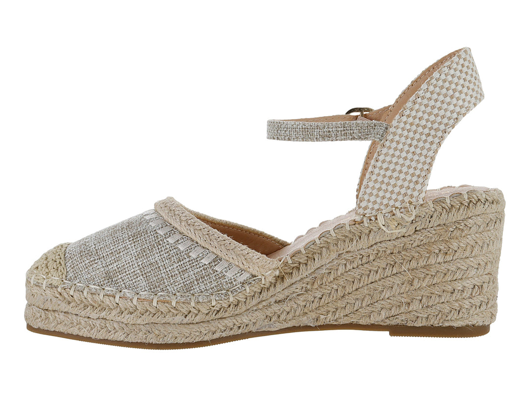 Sandalia de cuña color beige con punta cerrada, correa al tobillo y suela de fibras naturales tejidas.