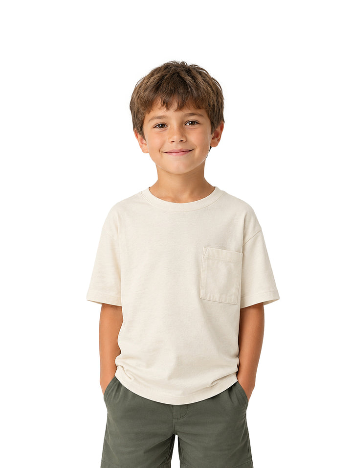 Niño vistiendo playera color beige claro con bolsillo frontal y shorts color verde olivo.