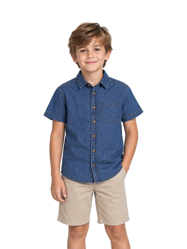 Niño vistiendo una camisa de mezclilla azul de manga corta con botones y un bolsillo en el pecho.