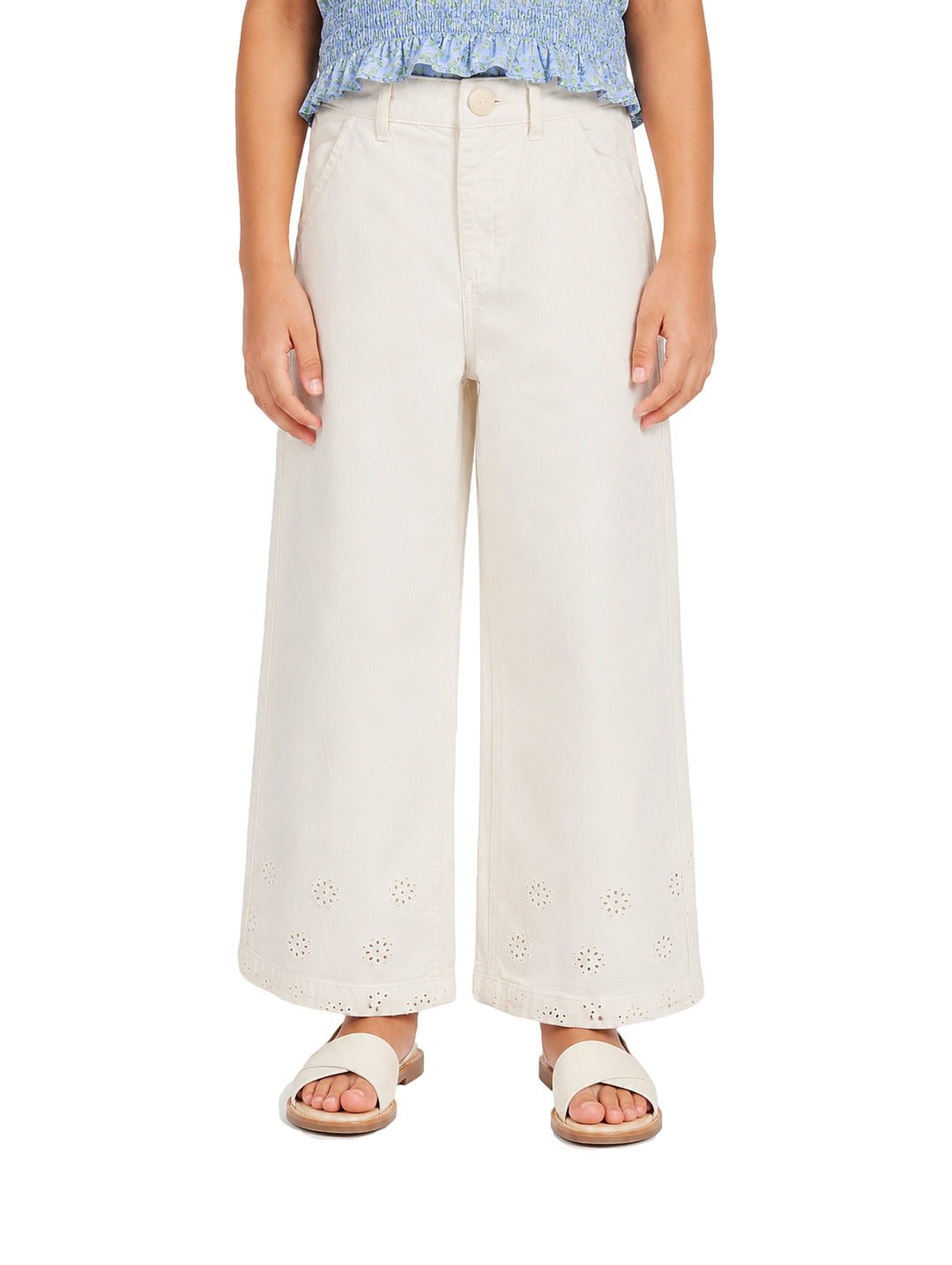 Pantalón beige claro para niña con pierna ancha y detalles bordados en la parte inferior.