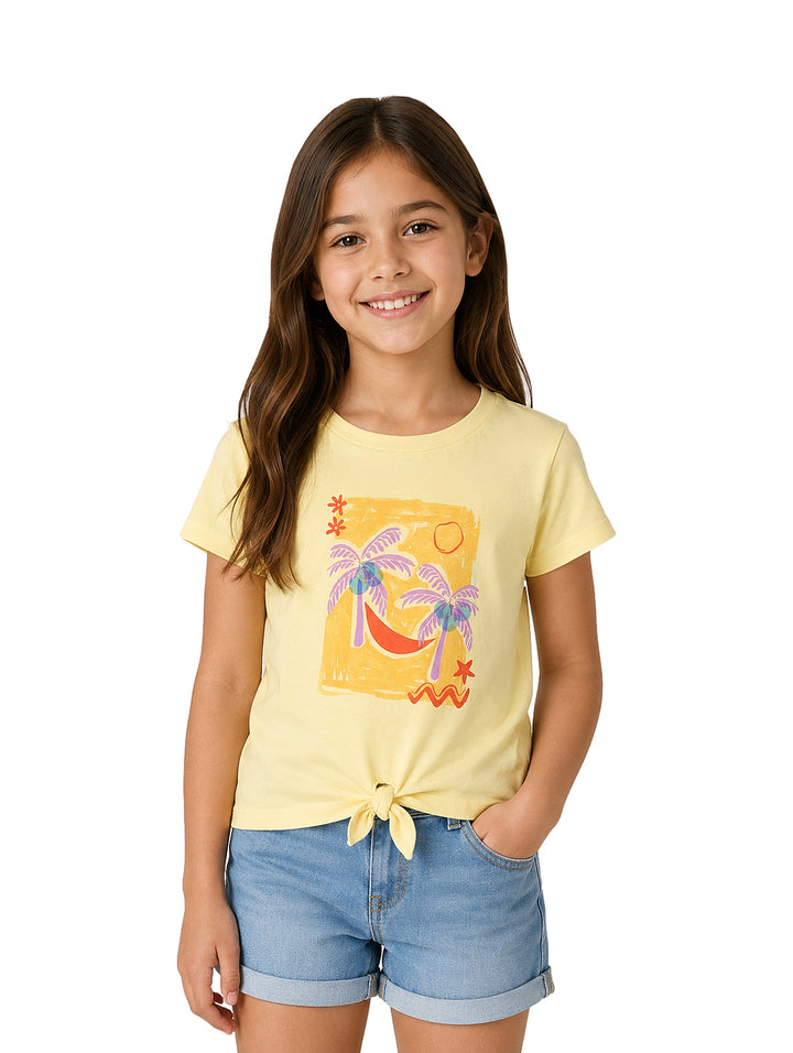Niña vistiendo camiseta amarilla con estampado de palmeras y nudo en la cintura
