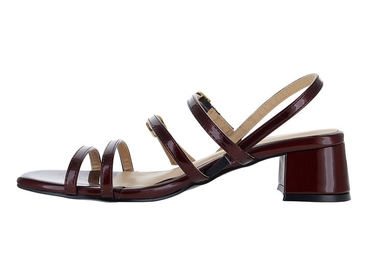 Sandalias de charol color vino con tacón cuadrado y tiras con hebillas doradas.