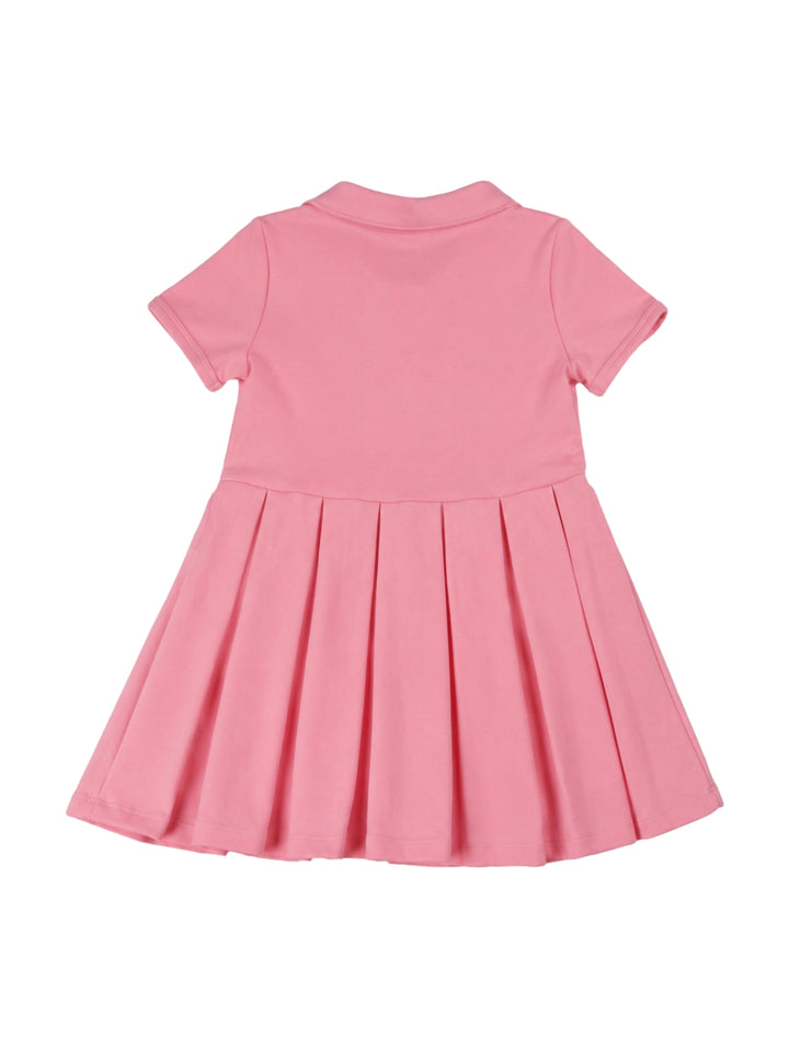 Niña vistiendo un vestido rosa estilo polo con cuello y botones