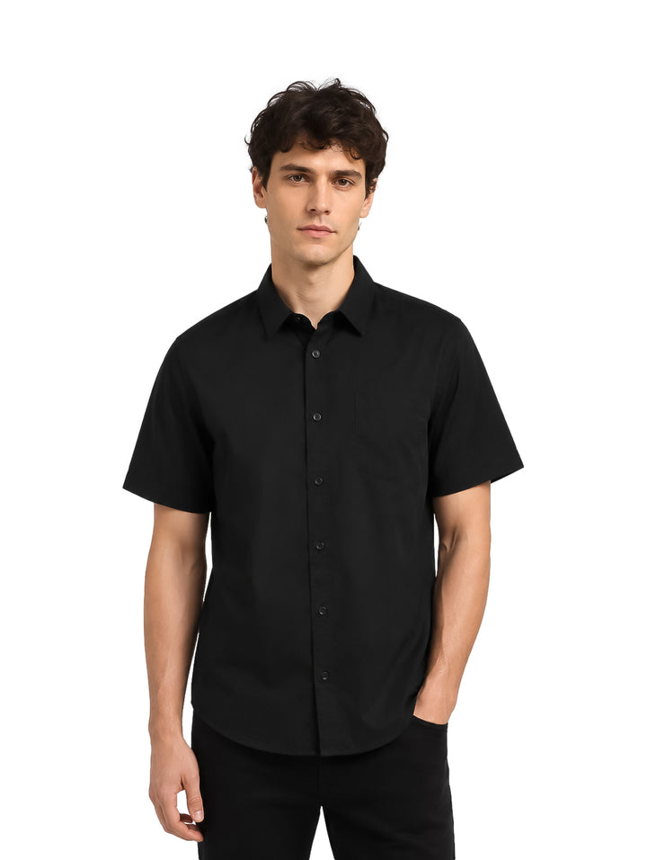 Hombre vistiendo una camisa negra de manga corta con botones y cuello.