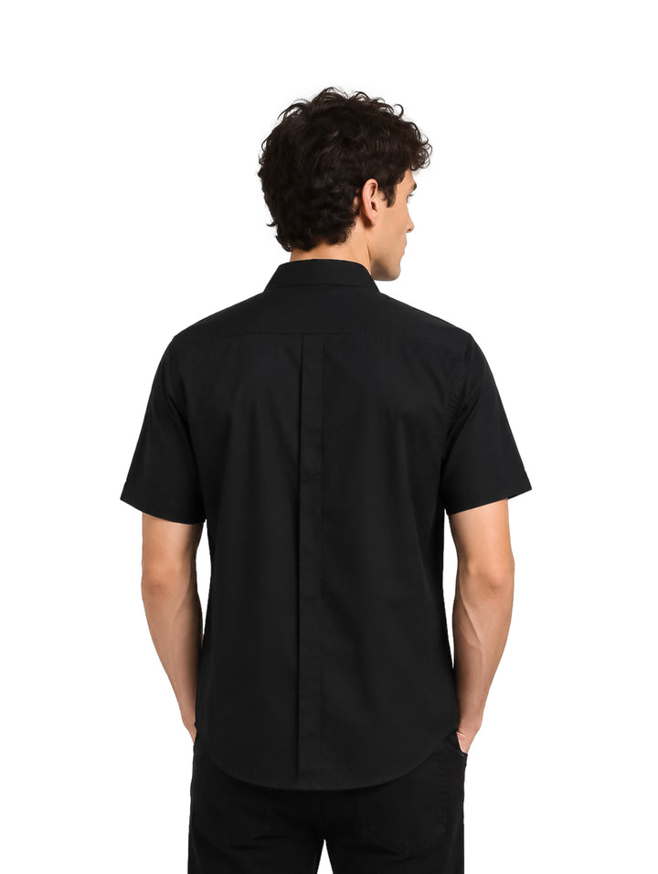 Hombre vistiendo una camisa negra de manga corta con botones y cuello.