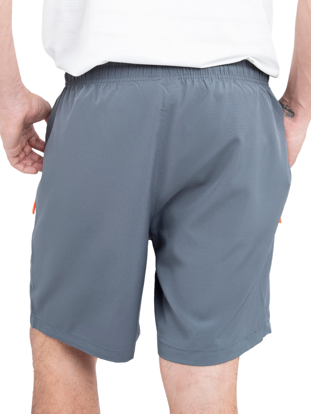 Hombre vistiendo shorts deportivos de color gris marca Voit con detalles en naranja en los bolsillos.