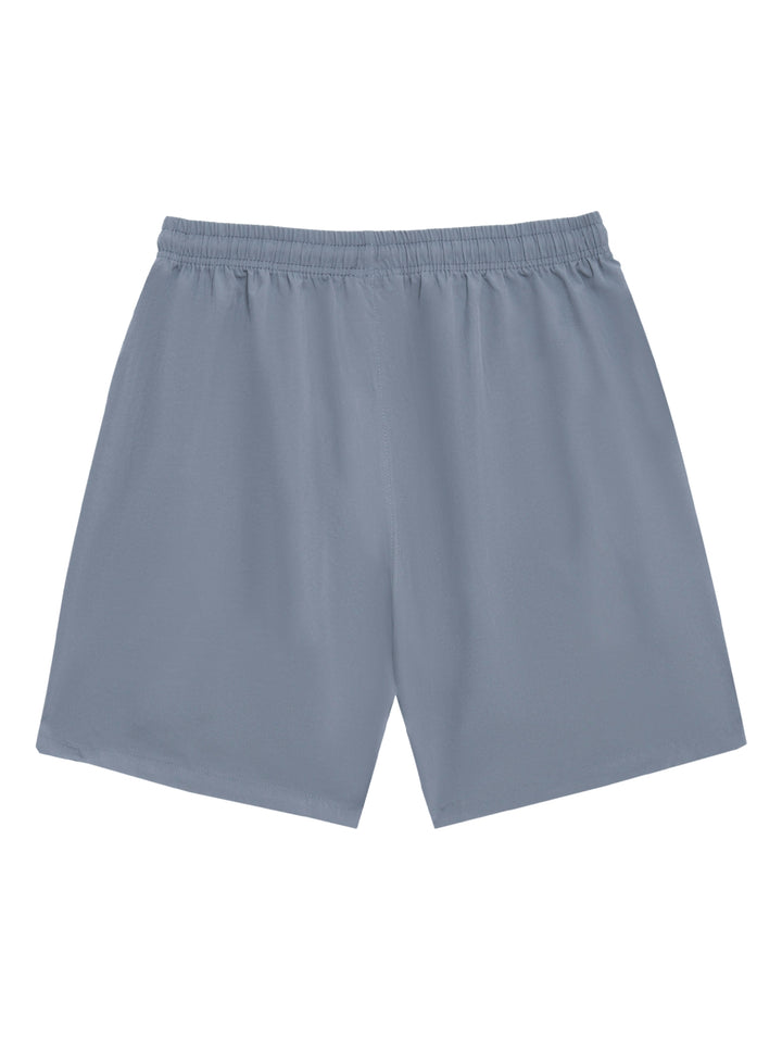 Hombre vistiendo shorts deportivos de color gris marca Voit con detalles en naranja en los bolsillos.