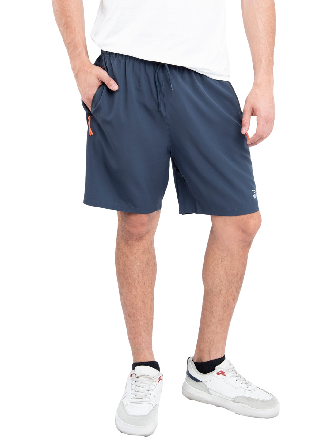 Hombre vistiendo shorts deportivos de color azul marino con detalles en naranja y calzado blanco.
