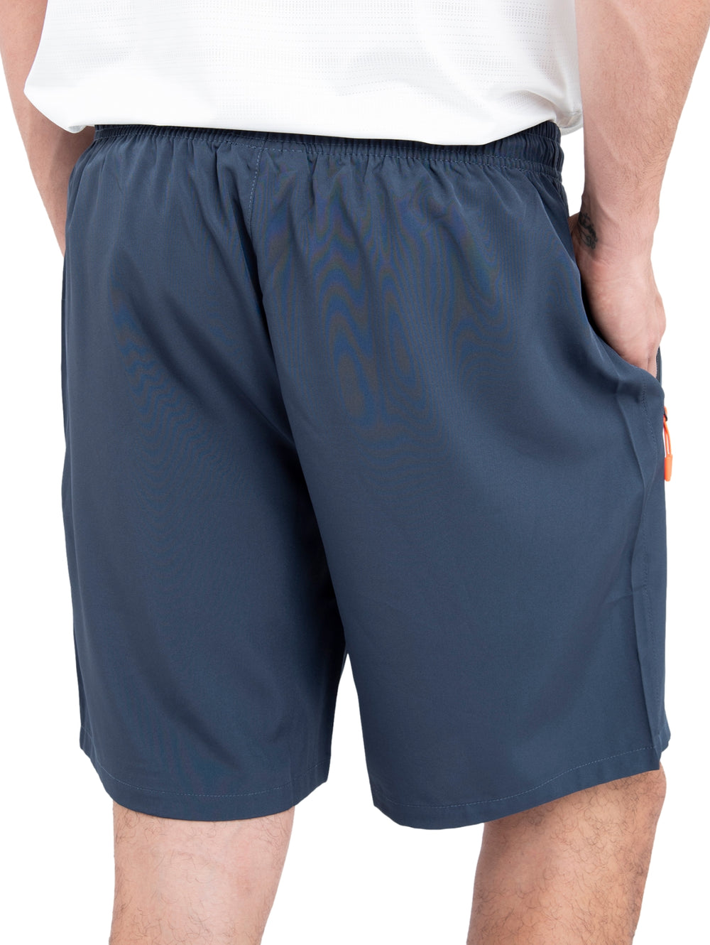 Hombre vistiendo shorts deportivos de color azul marino con detalles en naranja y calzado blanco.