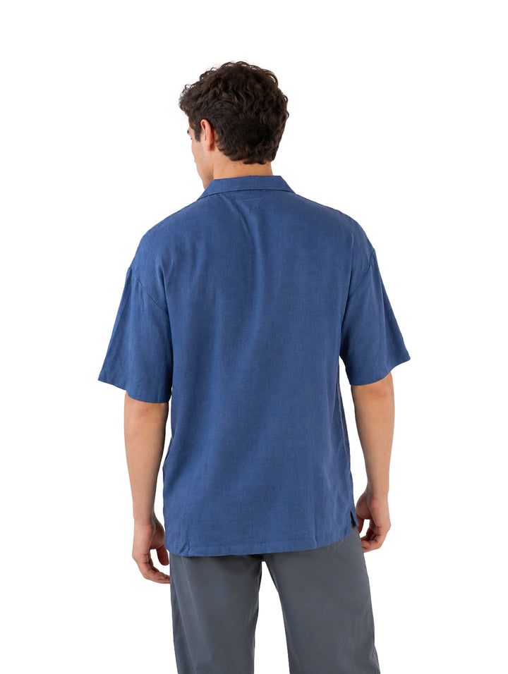 Hombre vistiendo una camisa de manga corta color azul denim.