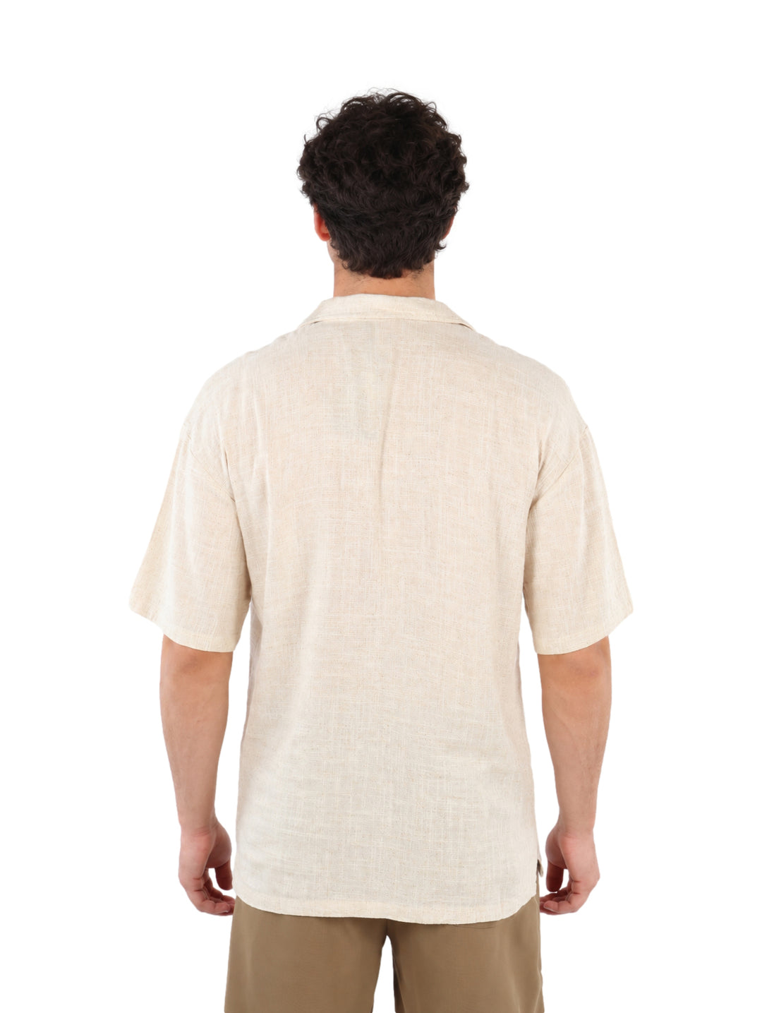 Hombre vistiendo una camisa de manga corta color beige con botones y pantalones caqui.