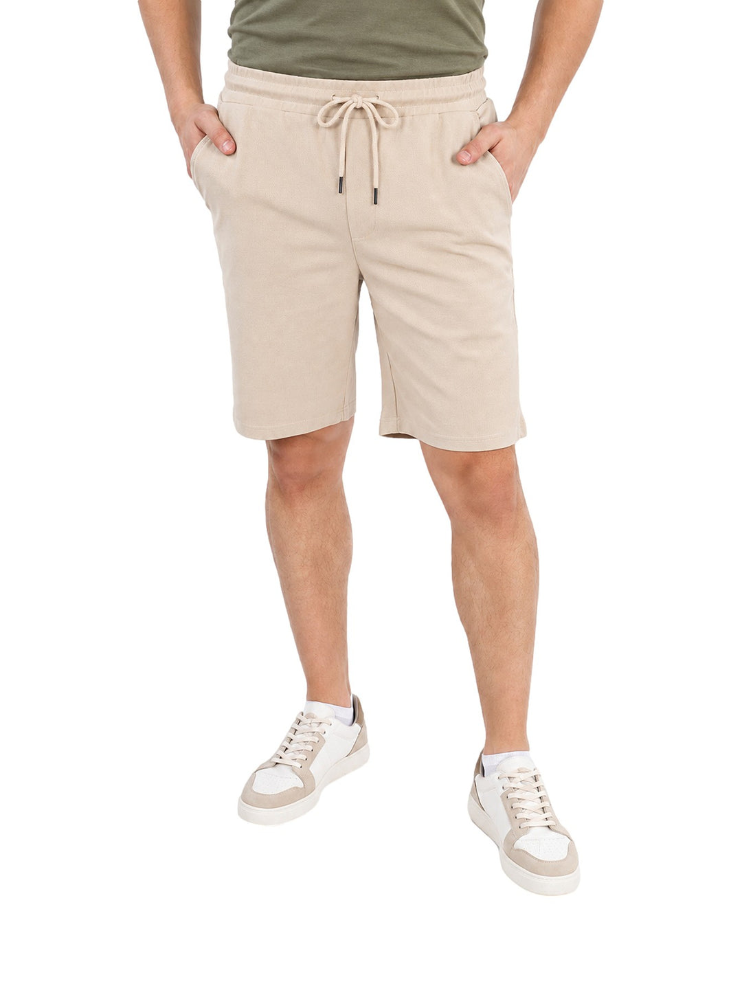 Hombre vistiendo short color sand con jareta y cintura elástica, estilo casual.