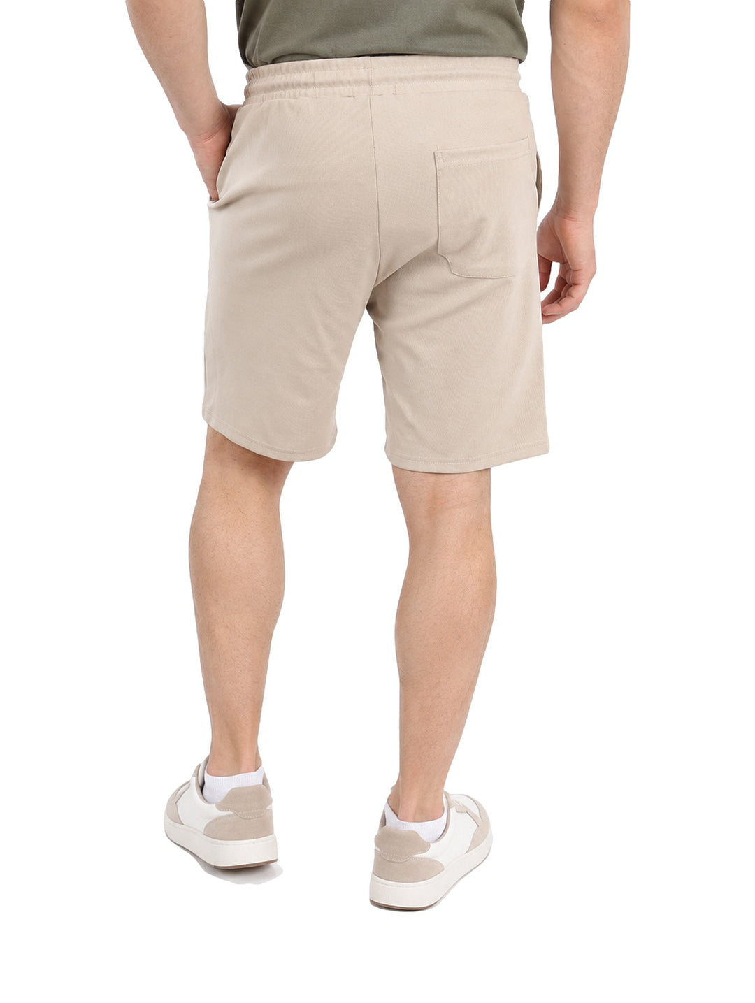 Hombre vistiendo short color sand con jareta y cintura elástica, estilo casual.