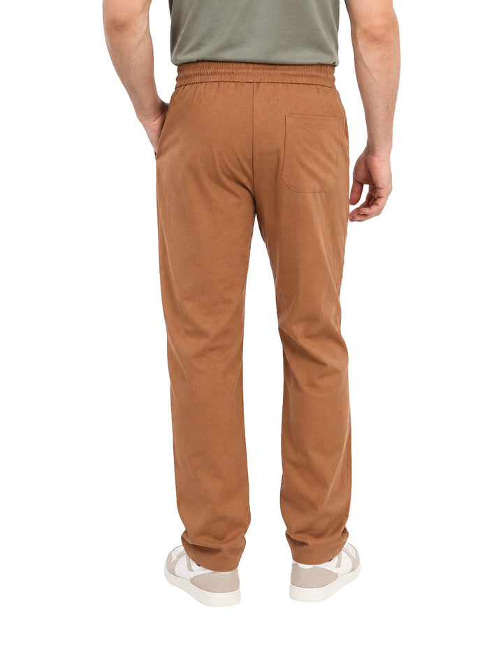 Hombre vistiendo pantalón ATOK color brown con cintura elástica y cordón ajustable.