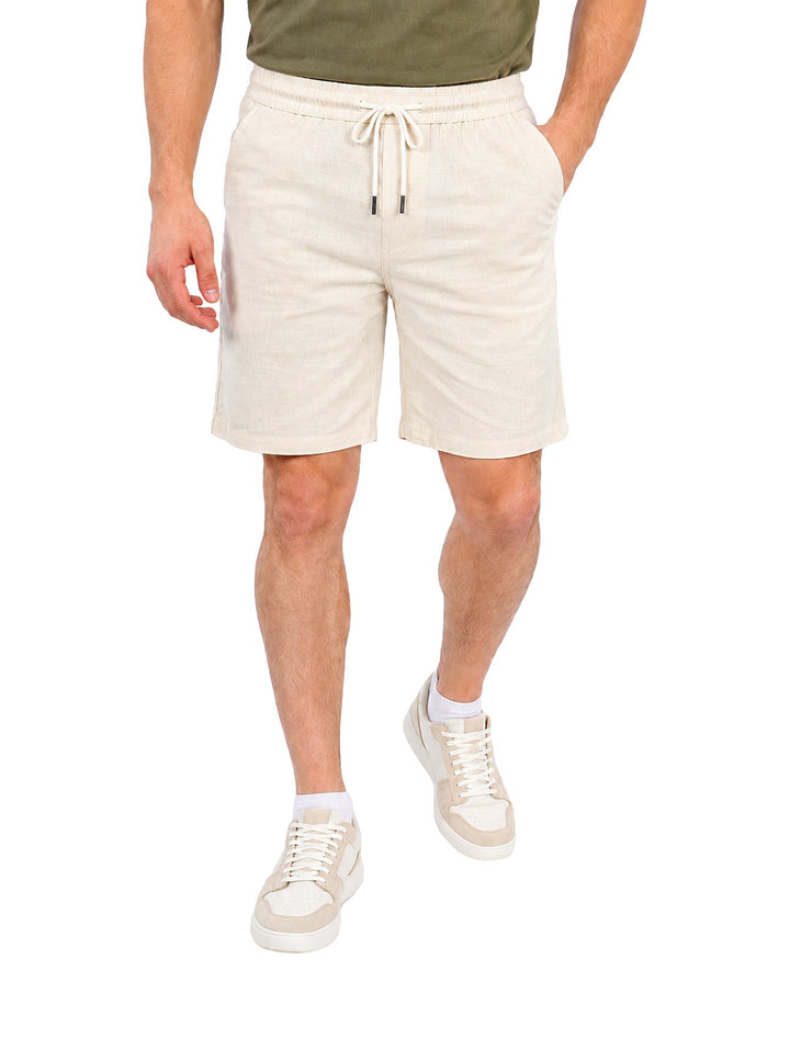 Hombre vistiendo short ATOK color off white con jareta y cintura elástica.