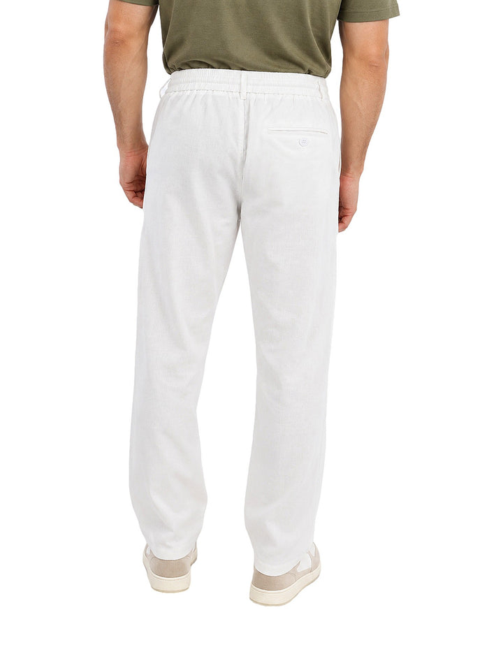 Hombre vistiendo pantalón ATOK color off white con cintura elástica y cordón, estilo casual.
