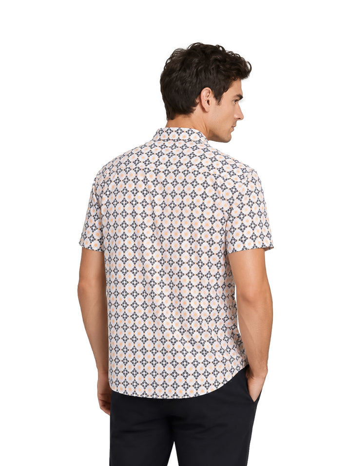 Hombre vistiendo camisa de manga corta color blanco y amarillo con estampado geométrico y pantalones oscuros.