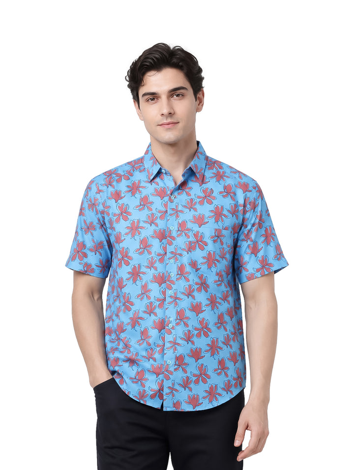 Hombre vistiendo camisa azul de manga corta con estampado floral rojo.