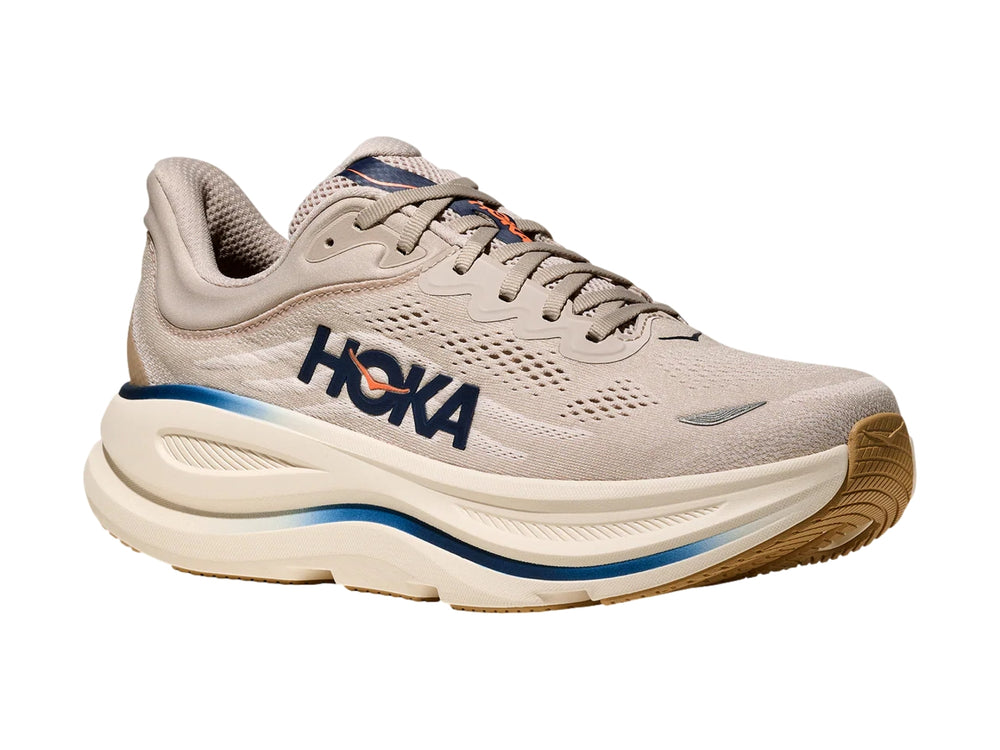 Tenis deportivos HOKA Bondi 9 en color beige con detalles en azul y suela blanca ancha.