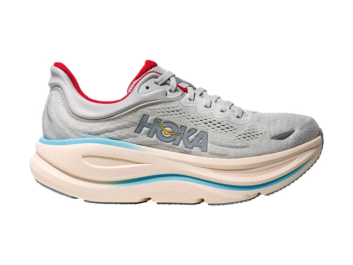 Tenis deportivos HOKA Bondi 9 en color gris con suela beige, detalles en azul claro y forro interior rojo.