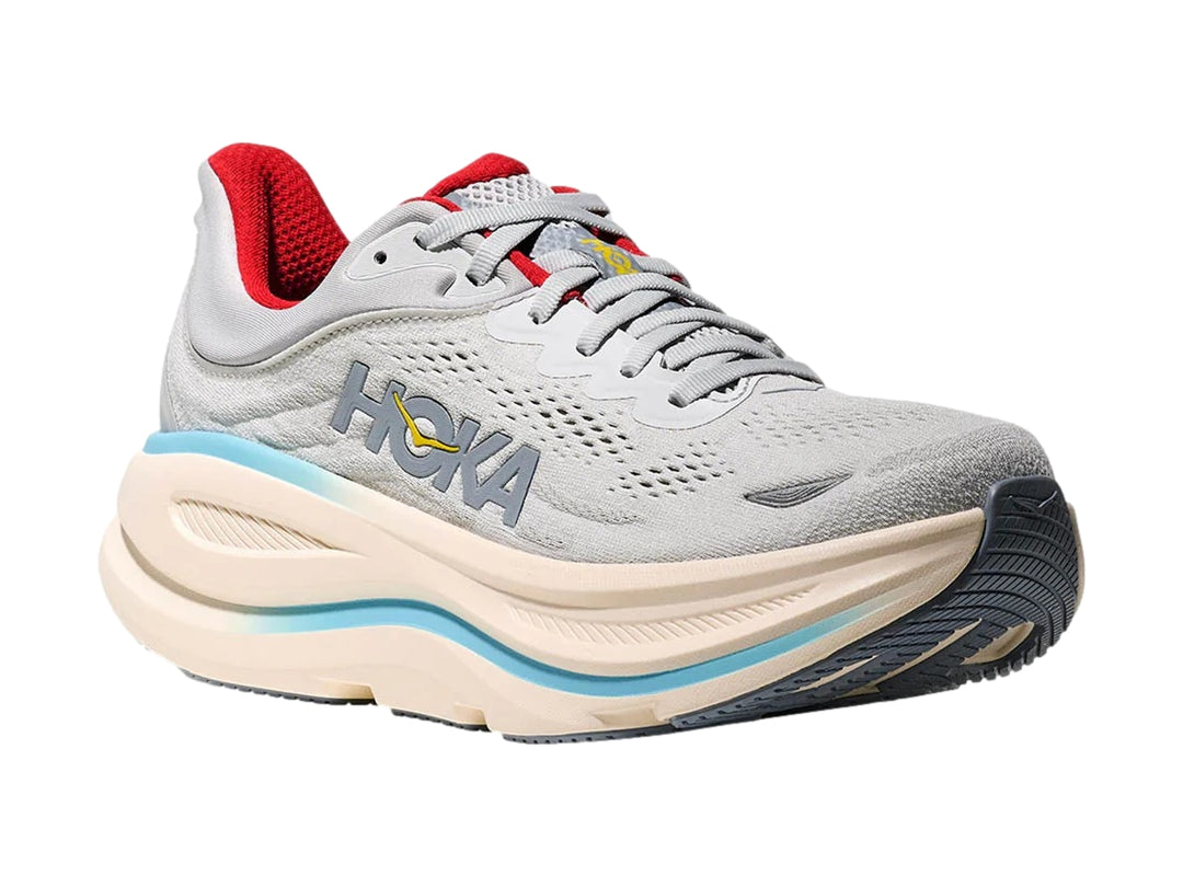 Tenis deportivos HOKA Bondi 9 en color gris con suela beige, detalles en azul claro y forro interior rojo.