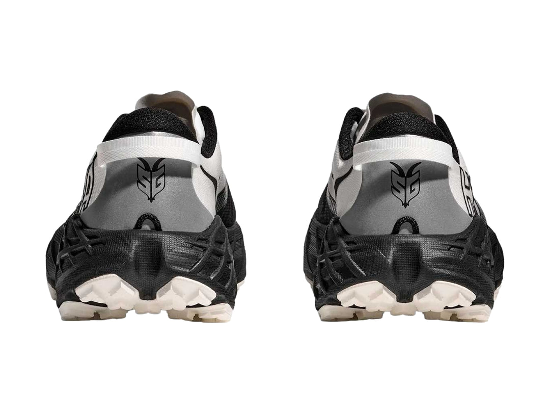Tenis HOKA Speedgoat 7 en colores blanco y negro con suela robusta para trail running.
