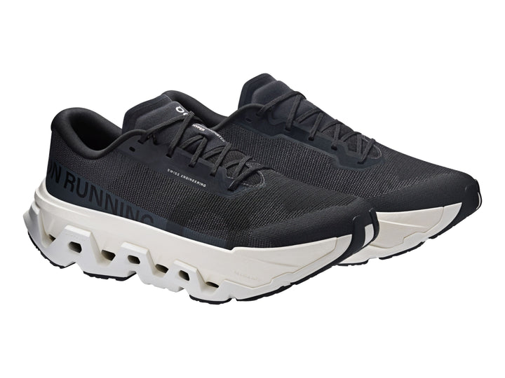 Tenis deportivos On Cloudmonster Hyper color negro con suela gruesa en tono marfil.