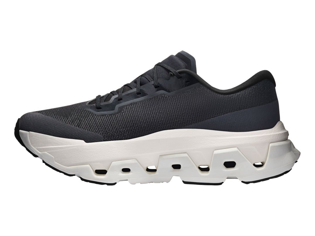 Tenis deportivos On Cloudmonster Hyper color negro con suela gruesa en tono marfil.